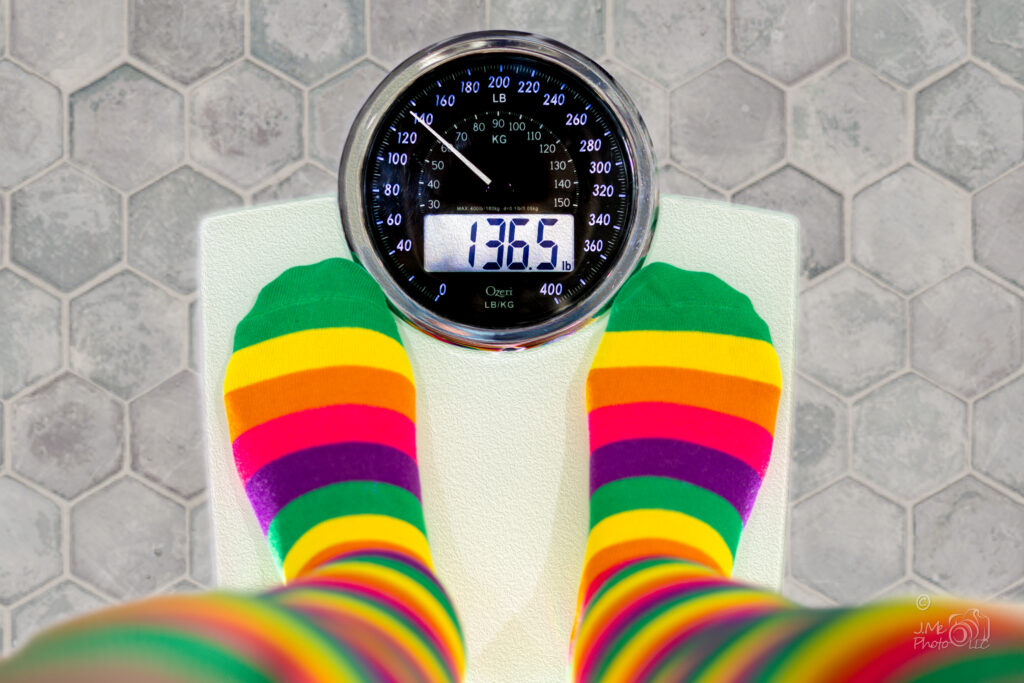 Photo of someone standing on a scale and the scale is lying about weight